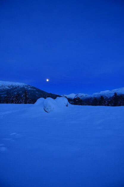 Snow landscape in norway with full moon at night