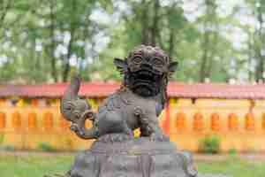 Photo snow lion statue on top of a large bronze incense burner in the courtyard of a buddhist datsan gunzechoinei