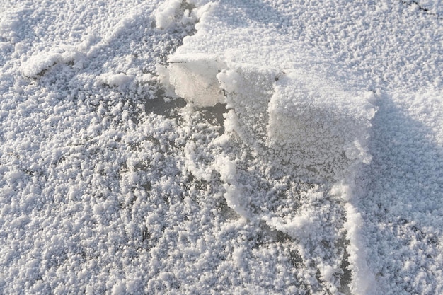 Snow lying on ice frosty surface