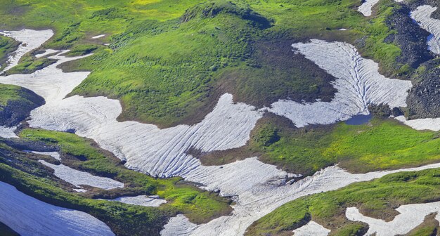 写真 春の山の斜面に雪が降る