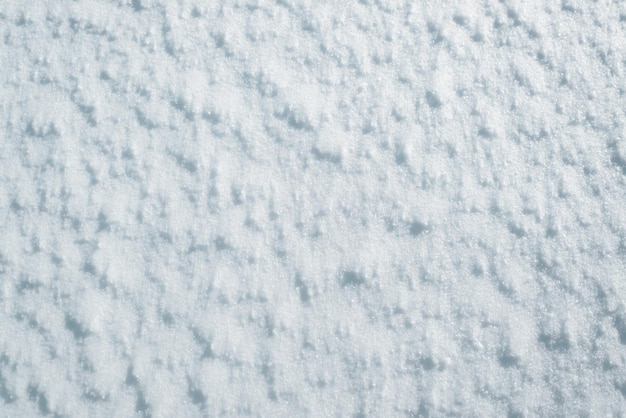 Snow outdoors on sunny winter day, top view close-up. Snow surface texture background