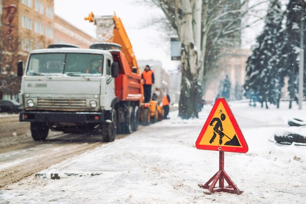 Снегоочиститель убирает снег с городской улицы.