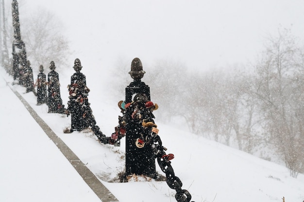 柵の手すりに雪が降る道路に大きな雪の吹きだまり