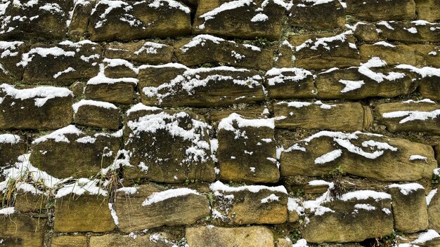 Foto neve su un muro di pietra