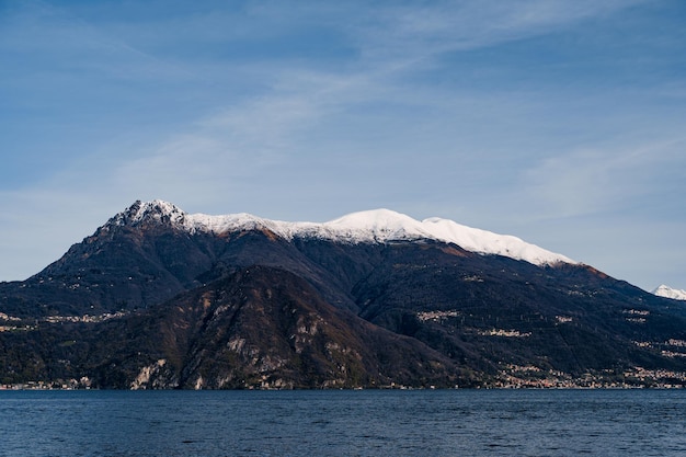 イタリアのコモ湖近くの山の頂上に雪が降る