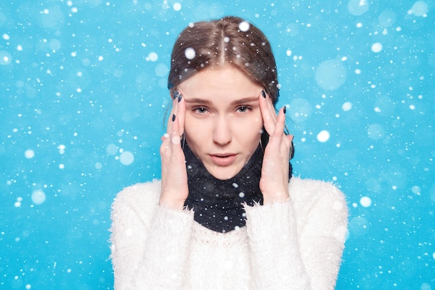 Snow, winter, christmas, illness, health care, people, medicine\
concept - throat pain. closeup of sick woman with sore throat\
feeling bad. beautiful girl touching neck with hand over snow\
background