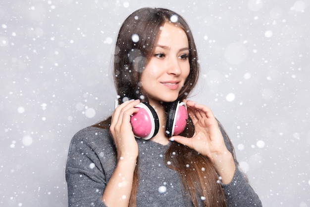 눈, 겨울, 크리스마스, 사람, 레저 및 기술 개념-행복 한 여자 또는 헤드폰에서 십 대 소녀 스마트 폰에서 음악을 듣고 눈 배경 위에 춤