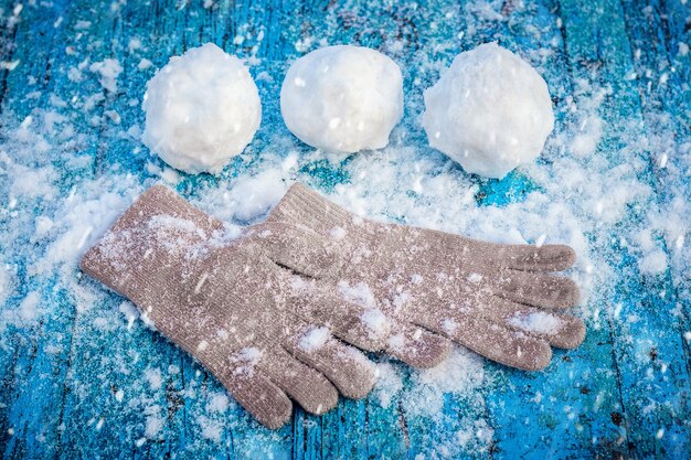 雪に覆われた表面に雪玉とミトンが横たわる