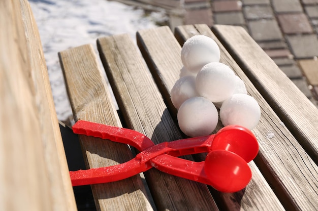 Snowballs and plastic tool on bench outdoors