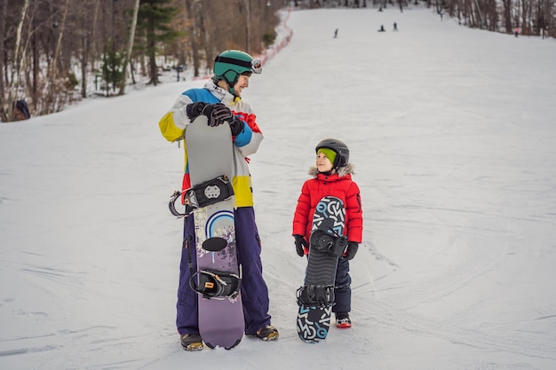 Snowboard instructor teaches a boy to snowboarding Activities for children in winter Children's winter sport Lifestyle