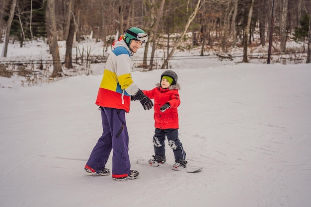 Snowboard instructor teaches a boy to snowboarding Activities for children in winter Children's winter sport Lifestyle