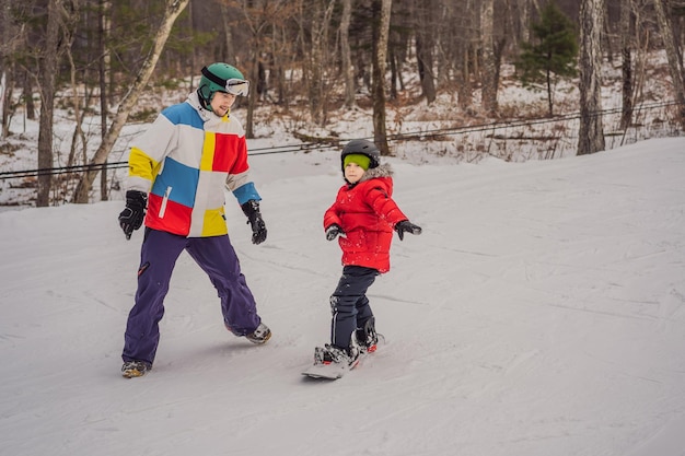 Snowboard instructor teaches a boy to snowboarding Activities for children in winter Children's winter sport Lifestyle