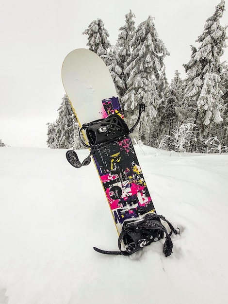 Foto snowboard steekt uit de sneeuw