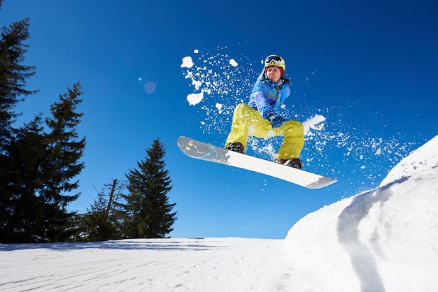 Snowboarden close-up in sprong op blauwe hemelachtergrond