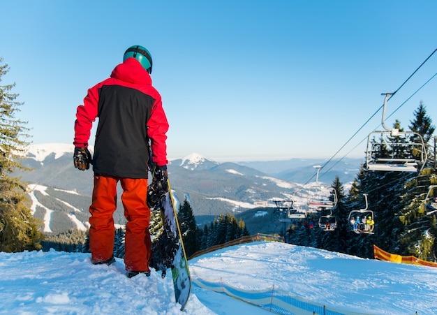 Snowboarder bovenop helling in winteravond