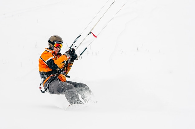 Snowboarder die een vlieger berijdt
