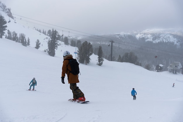 Lo snowboarder che gode di sciare in montagna la sera sul pendio presso la stazione sciistica invernale mammoth lakes