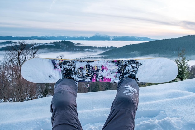 Snowboarder godendo la vista del tramonto sopra le montagne