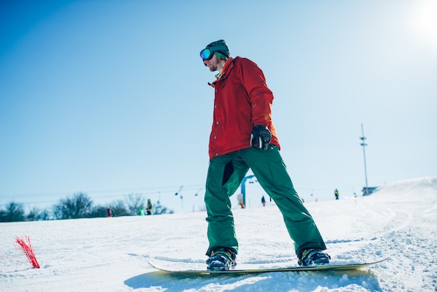 Snowboarder in bicchieri pone con bordo in mano