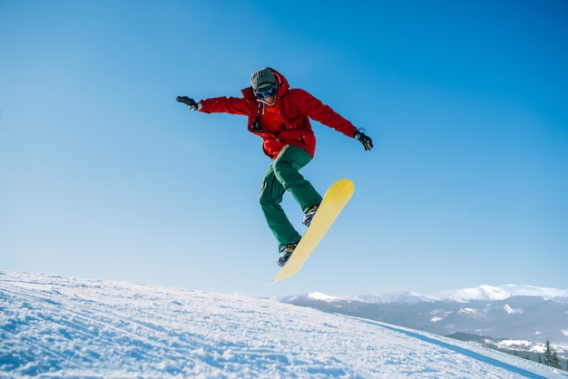 Photo snowboarder makes a jump on speed slope