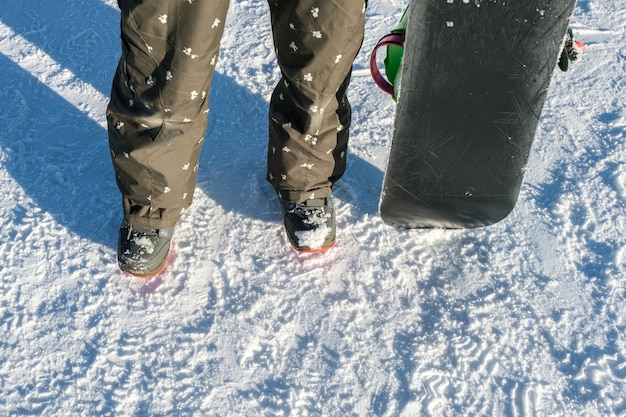 Snowboarder met snowboard staan op skipiste in de winter