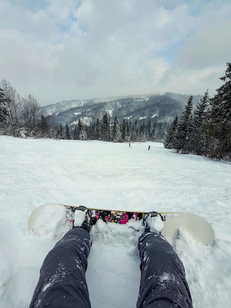 Snowboarder op de heuvel genietend van het landschap van de bergen