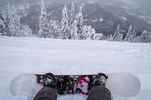 Foto snowboarder op de heuvel genietend van het landschap van de bergen