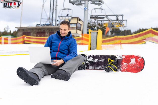 snowboarder typen op de laptop in de bergen winter