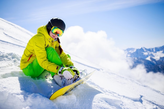 Snowboarder zittend met bergketen op de achtergrond