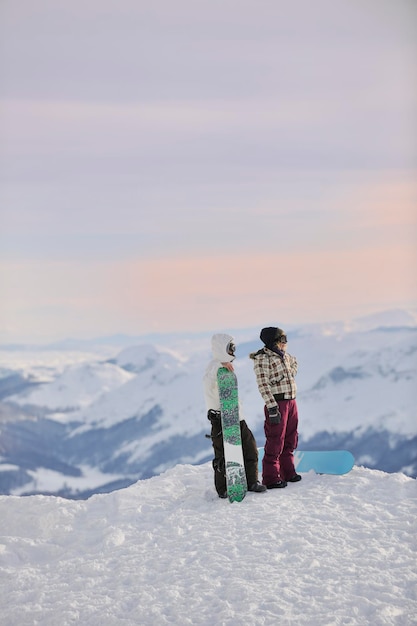 Пара сноубордистов на вершине горы