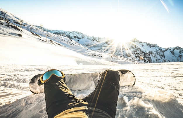 Snowboarderzitting bij zonsondergang ontspant ogenblik in Europese de skitoevlucht van Alpen