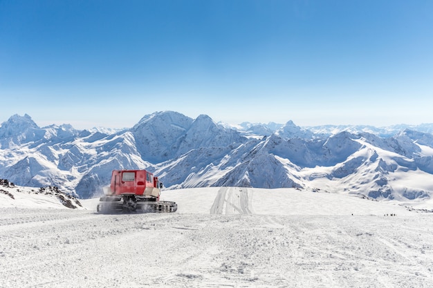 Gatto delle nevi su un pendio in alto nelle montagne