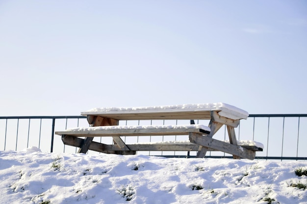 Snowcovered bench and table for relaxing in winter