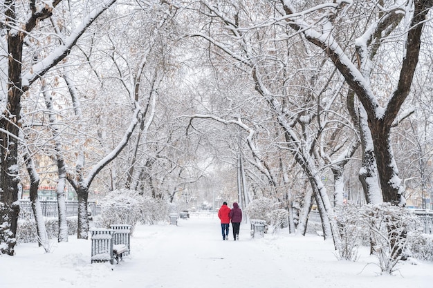 Snowcovered city a man and a woman walk along a snowy alley