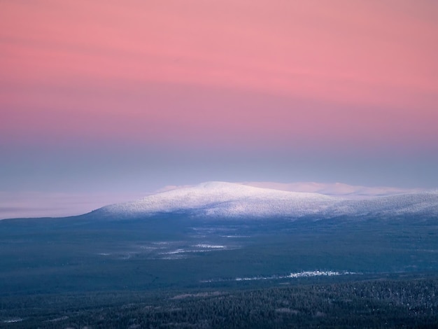 Snowcovered polar cone hill in winter early in the morning\
winter polaris landscape view of the snowcovered tundra and hills\
cold winter weather harsh northern climate