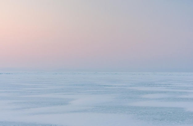 Photo snowdrifts on the ice surface during sunset