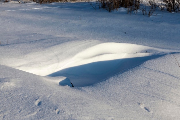 冬の白いふわふわの雪の雪の吹きだまり、冬の降雪後の雪の吹きだまり