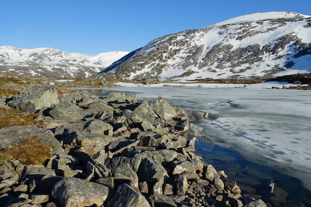 Заснеженные горы с замерзшим озером и голубым небом, норвегия