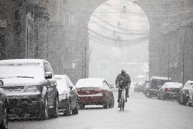 Snowfall on snow-covered narrow city streets, selective focus.