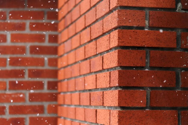 Snowflakes falling in front of brick wall