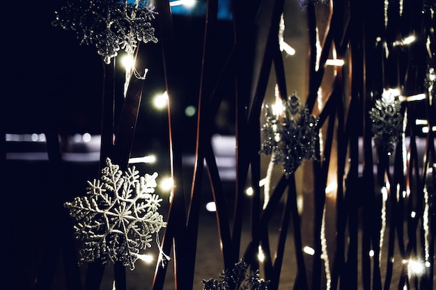 Photo snowflakes on illuminated metal window at night