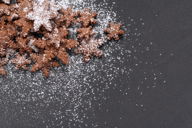 Biscotti a forma di fiocchi di neve cosparsi di zucchero a velo su sfondo grigio. copia spazio. dolci fatti in casa