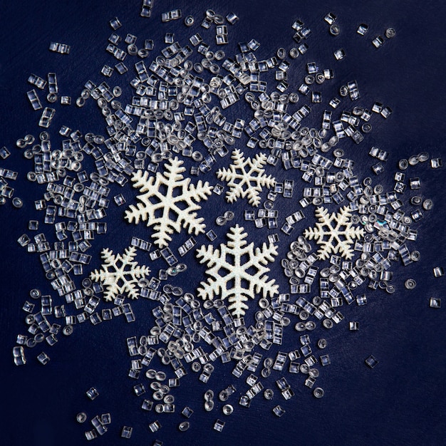 Photo snowflakes with sparkles and a transparent bead on a dark blue. flat lay.