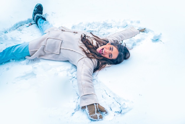 Snowing winter beauty fashion concept. Enjoying nature wintertime. Beautiful girl in snow. Winter