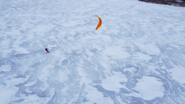 氷湖の冬のスノーカイトカイトサーフィンスポーツ空中ドローンビュー