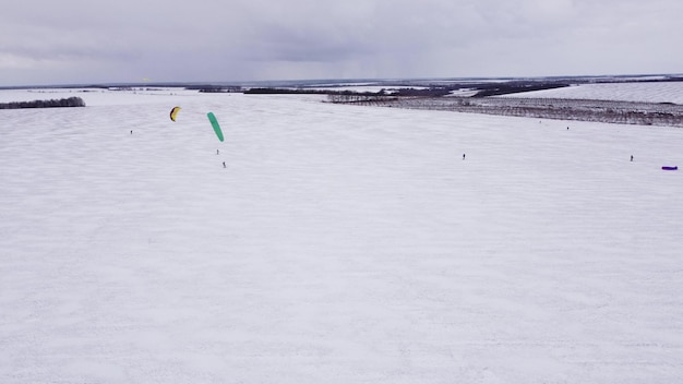 氷湖の冬のスノーカイトカイトサーフィンスポーツ空中ドローンビュー