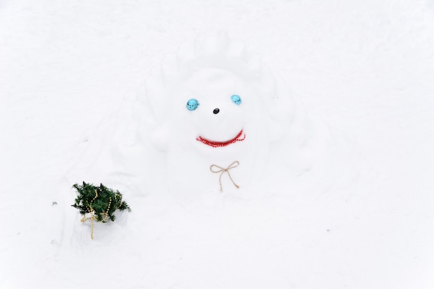 Pupazzo di neve appena percettibile sullo sfondo di cumuli di neve bianchi nel paesaggio invernale. molta neve.