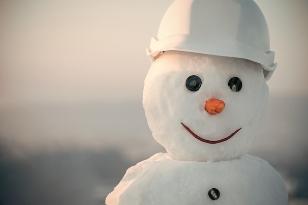 Foto costruttore di pupazzo di neve nel casco.