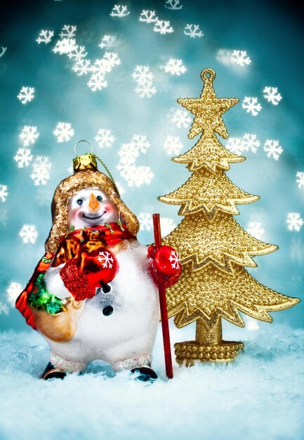 Snowman and a Christmas fur-tree with Blue Holiday Background.