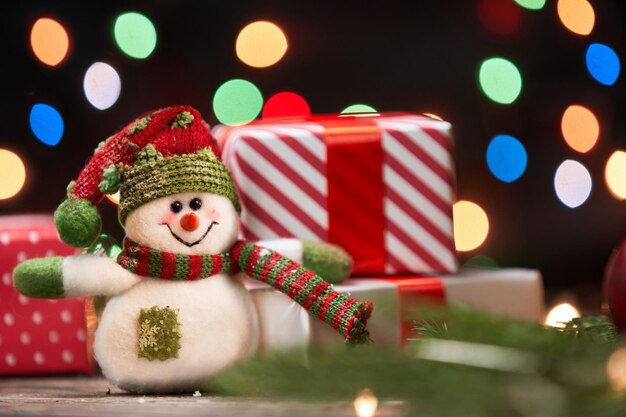 Snowman and a christmas gift on a festive background